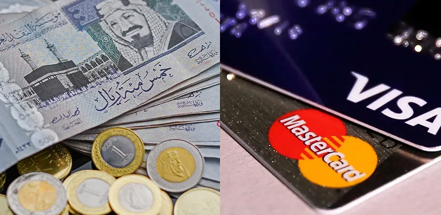 Money and shopping essentials for Umrah 2026 including Saudi Riyals, debit and credit cards, secure money belt, and emergency contact information for safe travel